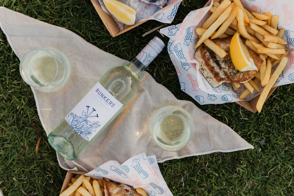 Bunkers wine bottle on the grass with fish and chips 